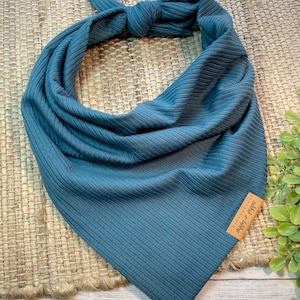 May include: A dark blue ribbed bandana with a brown leather tag that says "Happy & Co."