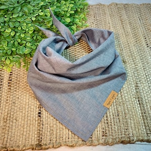 May include: A light blue bandana with a brown tag that says "Happy & Free".
