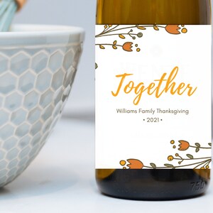 May include: A white wine bottle with a label that says "We're Better Together" with a floral design and the text "Williams Family Thanksgiving - 2021 - "