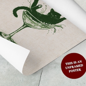 May include: An unframed poster featuring a green illustration of a black cat lounging in a martini glass with water splashing out. The poster has a beige background and a red circle with white text that reads "THIS IS AN UNFRAMED POSTER".