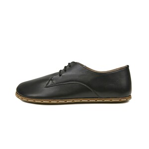 May include: Black leather lace-up shoes with a brown stitched sole.