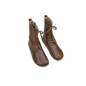 May include: A pair of brown leather ankle boots with laces. The boots have a rounded toe and a low heel.