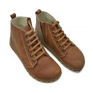 May include: A pair of brown leather ankle boots with laces. The boots have a rounded toe and a flat sole.