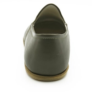 K&ouml;nnte beinhalten: Ein Paar dunkelgr&uuml;ne Lederschuhe zum Reinschl&uuml;pfen mit brauner Sohle.