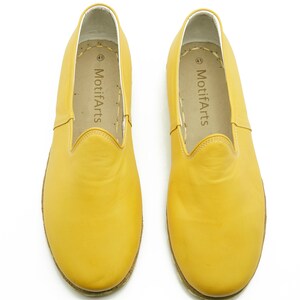 Puede incluir: Un par de zapatos de cuero amarillo de vestir sin cordones con el nombre de la marca "MotifArts" impreso en el interior de cada zapato.