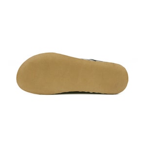 May include: The bottom of a brown leather sandal with a textured sole.
