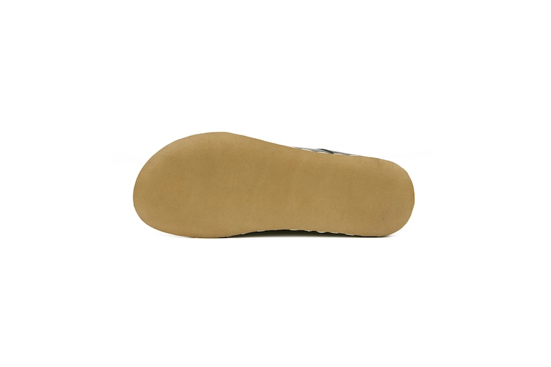 May include: The bottom of a brown leather sandal with a textured sole.