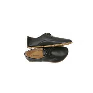 May include: A pair of black leather lace-up shoes with a brown stitched edge. The shoes are stacked on top of each other.