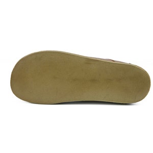 May include: The bottom of a brown leather shoe with a tan rubber sole.