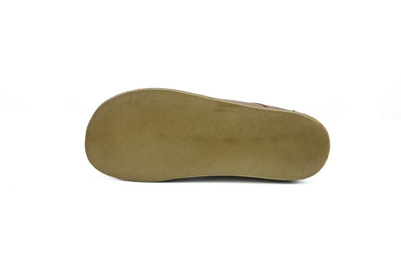 May include: The bottom of a brown leather shoe with a tan rubber sole.