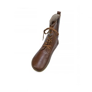 May include: Brown leather ankle boots with laces. The laces are a lighter brown color. The boots have a rounded toe.