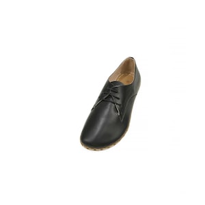May include: Black leather lace-up shoes with a brown sole.