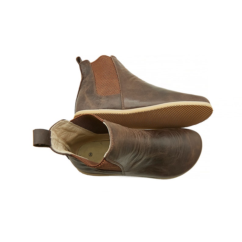 Puede incluir: Un par de botines de cuero marr&oacute;n con paneles laterales el&aacute;sticos. Las botas tienen una suela de goma marr&oacute;n.