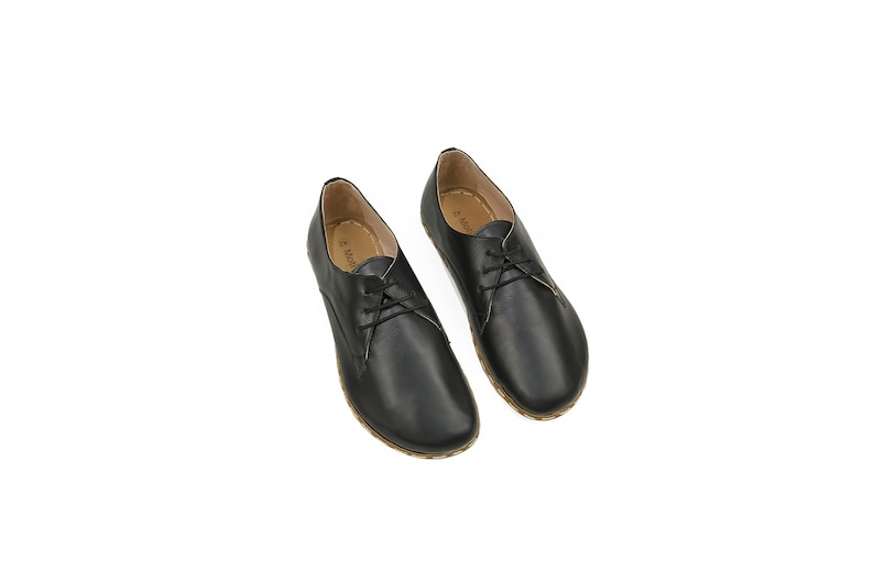 May include: A pair of black leather lace-up shoes with a rounded toe and a low heel.