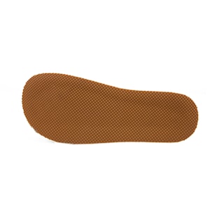 Puede incluir: Primer plano de la suela de goma marr&oacute;n de un zapato con un patr&oacute;n texturizado.