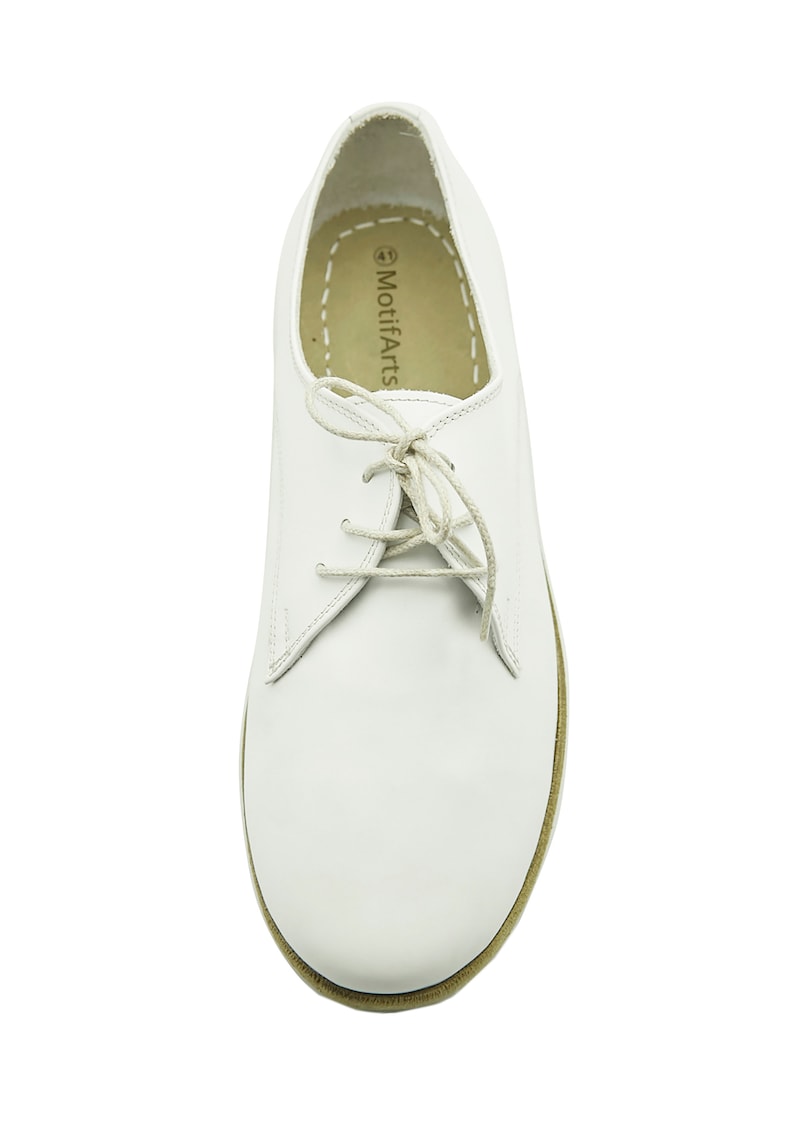 Puede incluir: Zapatos blancos de cuero con cordones y suela marr&oacute;n. Los zapatos tienen un detalle cosido alrededor del borde de la suela y el nombre de la marca "MotifArts" est&aacute; impreso en el interior del zapato.