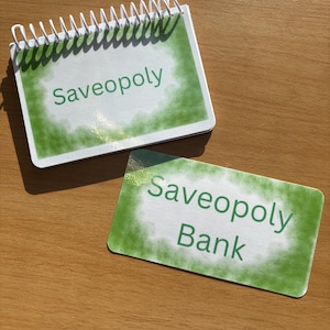Saveopoly Board Game.     Cash stuffing challenge game board and Book