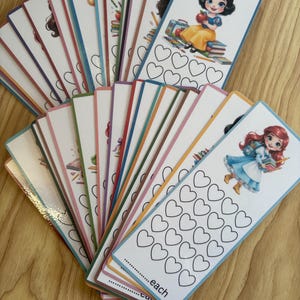 May include: A collection of rectangular paper bookmarks fanned out, each featuring a colourful cartoon character illustration at the top and a grid of empty heart outlines below for tracking progress, with the word each printed at the bottom.