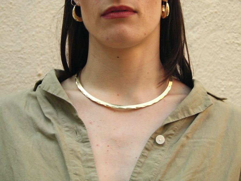 Bold and elegant, this rigid golden brass choker draws inspiration from Celtic and Viking jewelry. Handmade and lightweight, it's perfect for those who love powerful, minimalist designs. A timeless piece that blends ancient symbolism with modern style.