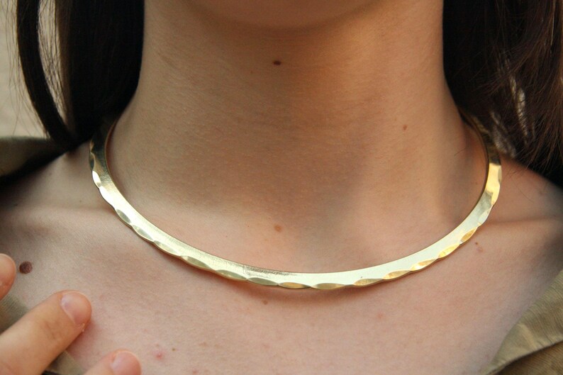 Handcrafted golden brass choker with a Celtic and Viking-inspired design. This rigid collar is both strong and feminine — perfect for warrior spirits and lovers of brutalist, minimalist jewelry. Comfortable to wear and fits effortlessly with any outfit.