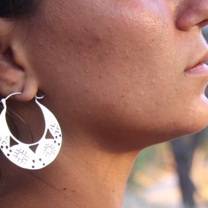 Woman wears Indian silver earrings. Indian silver jewelry. Indian hoop earrings.