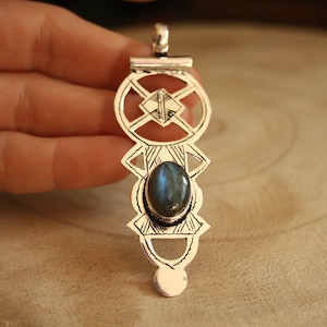 Puede incluir: Pendiente de plata con un diseño geométrico y una piedra preciosa de labradorita azul.
