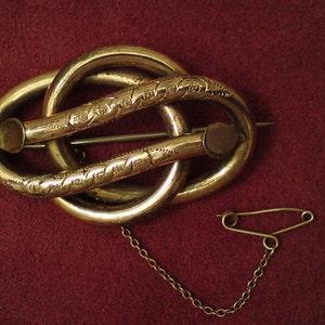 Antique Victorian pinchbeck gold-plated knot brooch with safety chain