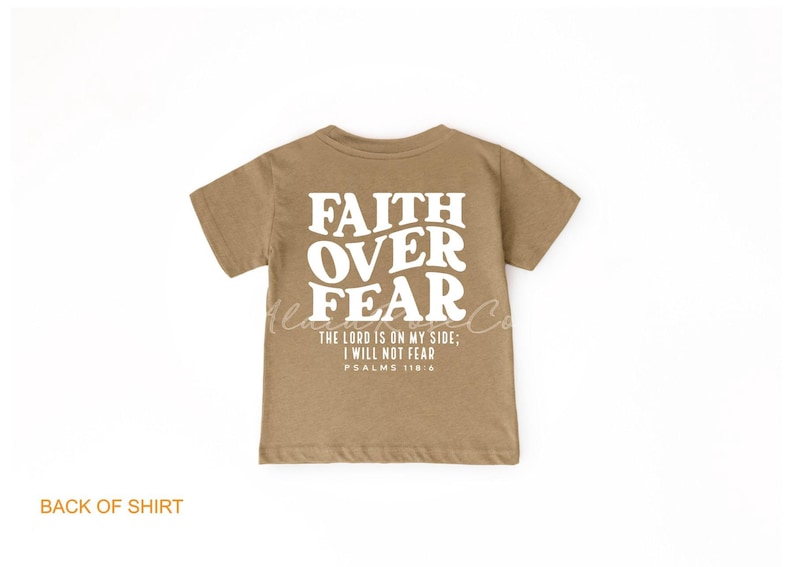 Puede incluir: Una camiseta de manga corta de color marr&oacute;n claro con el texto "FAITH OVER FEAR" en blanco. La camiseta tambi&eacute;n incluye el texto "THE LORD IS ON MY SIDE; I WILL NOT FEAR" y "PSALMS 118:6" en blanco.