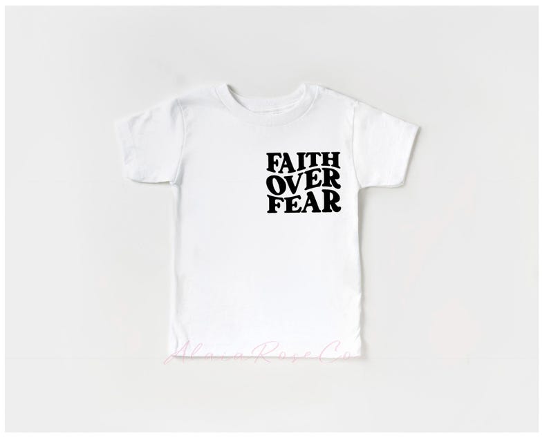 Puede incluir: Camiseta blanca con texto negro que dice "Faith Over Fear" en una fuente retro.