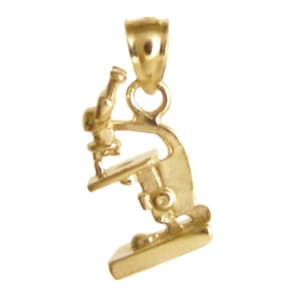 May include: A gold-colored microscope pendant. The pendant is a detailed miniature replica of a microscope, featuring a base, stage, objective lenses, and eyepiece. The pendant has a loop at the top for a chain.
