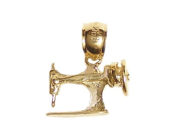 May include: A gold-colored pendant in the shape of a vintage sewing machine. The pendant has intricate details, including a needle, a hand wheel, and a base. The bail is at the top for attaching to a chain. The pendant is likely made of gold.