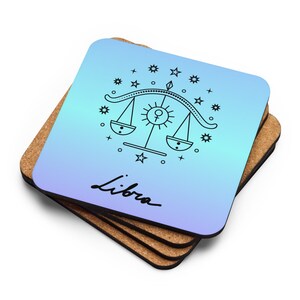 May include: Set of four blue and purple gradient coasters with a black outline of the Libra zodiac symbol and the word "Libra" in cursive.