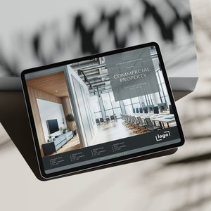 May include: A tablet displaying a website for commercial property. The website features a photo of a modern office space with a large window and a conference table. The text "COMMERCIAL PROPERTY" is displayed in a black box at the top of the page.