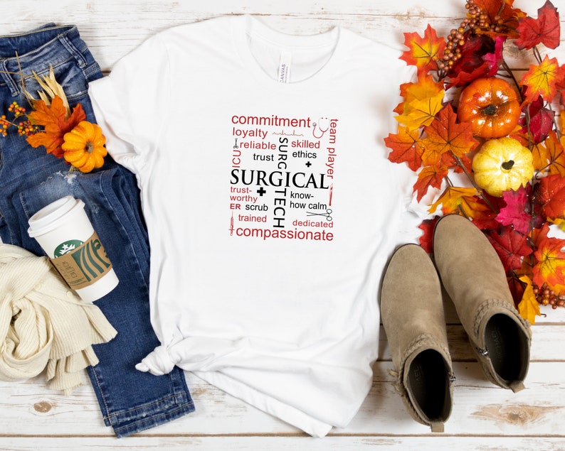 May include: White t-shirt with a red and black word cloud design that says "Surgical Tech". The design includes words like "commitment", "loyalty", "trust", "know-how", "dedicated", and "compassionate".
