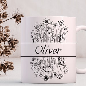 Puede incluir: Taza de cer&aacute;mica blanca con un contorno negro de flores y el nombre "Oliver" impreso en la parte delantera.