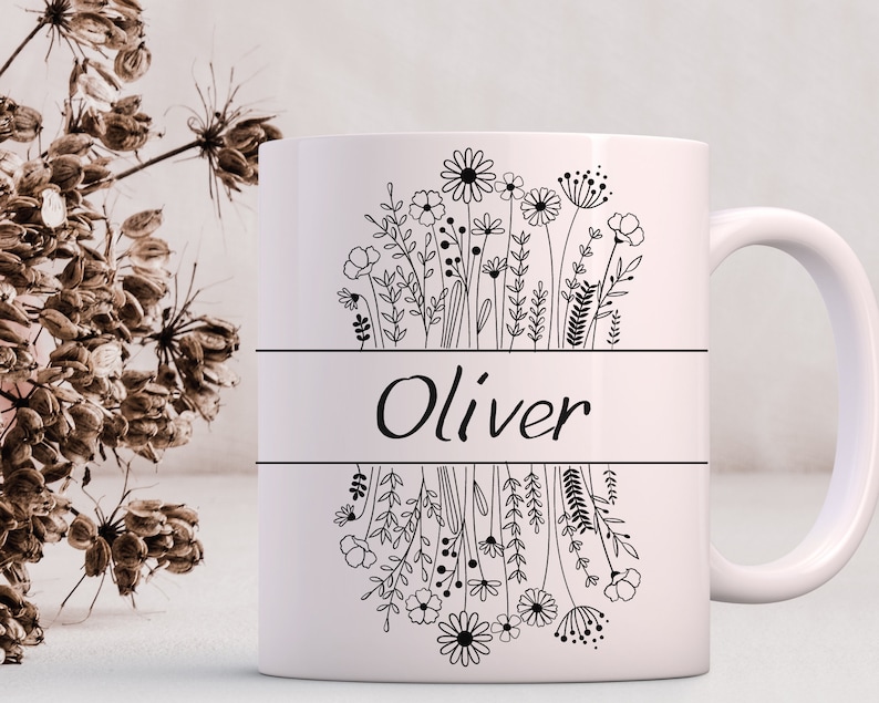 Puede incluir: Taza de cer&aacute;mica blanca con un contorno negro de flores y el nombre "Oliver" impreso en la parte delantera.