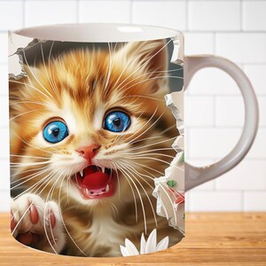Pu&ograve; includere: Una tazza in ceramica bianca con un'immagine colorata di un gattino zenzero con occhi azzurri che spunta da un buco nella tazza. Il gattino ha la bocca aperta e guarda direttamente lo spettatore.