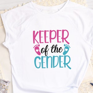 May include: White t-shirt with the text "Keeper of the Gender" in pink and blue with a pink and blue footprint on either side of the text.