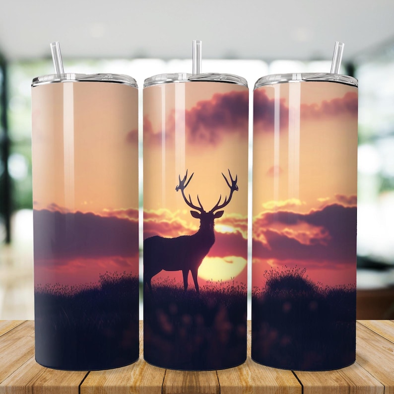 May include: A stainless steel tumbler with a sunset and a silhouette of a deer with antlers. The tumbler is a popular choice for outdoor activities and everyday use.