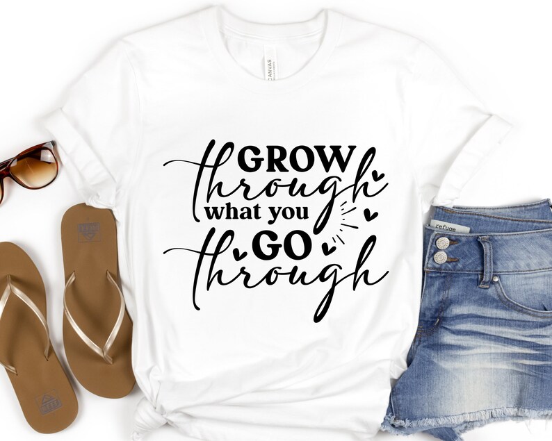 May include: White t-shirt with black text that reads "GROW through what you GO through" with small hearts around the text.