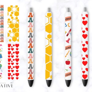 K&ouml;nnte beinhalten: F&uuml;nf wei&szlig;e Stifte mit verschiedenen bunten Designs. Die Designs umfassen ein Wabenmuster, einen sich wiederholenden Buchstaben A, ein Muster aus Schulutensilien und ein Muster aus roten Herzen.