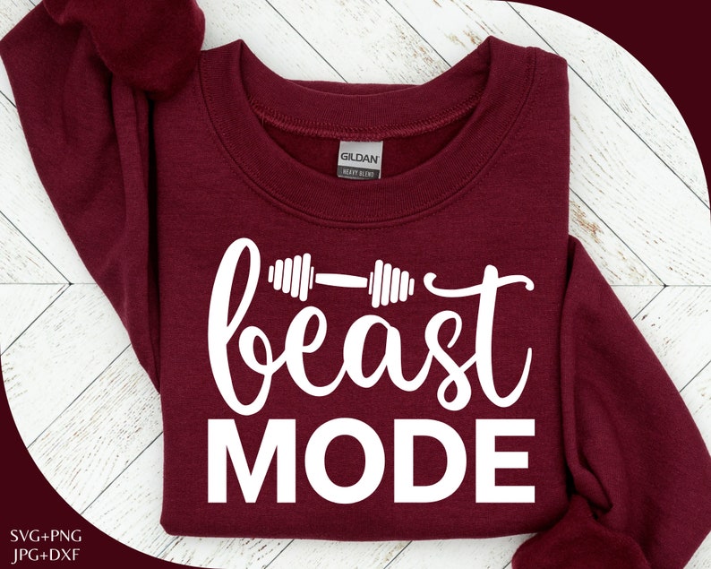 Op de afbeelding: Een maroon sweatshirt met de tekst "beast MODE" in witte letters. De tekst wordt vergezeld door een witte haltergrafiek.