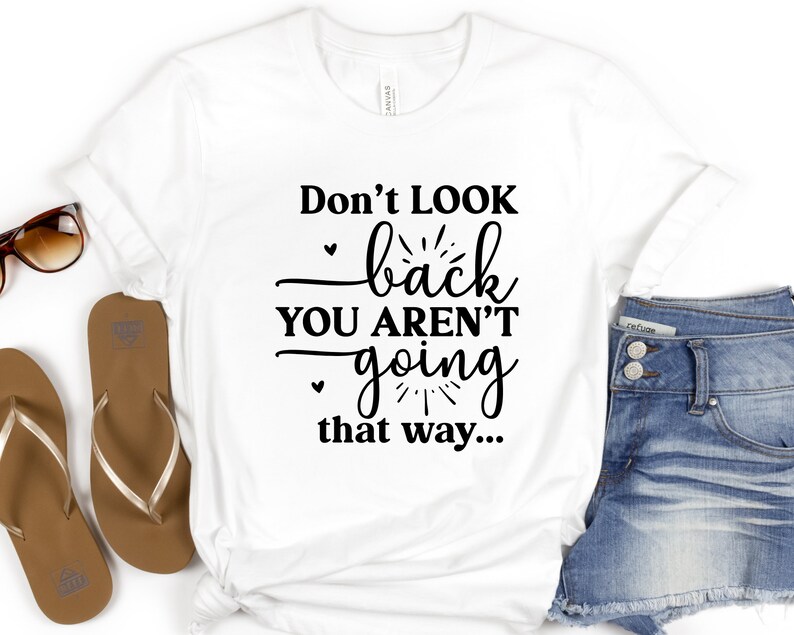 May include: White t-shirt with the text "Don't look back you aren't going that way..." printed in black.