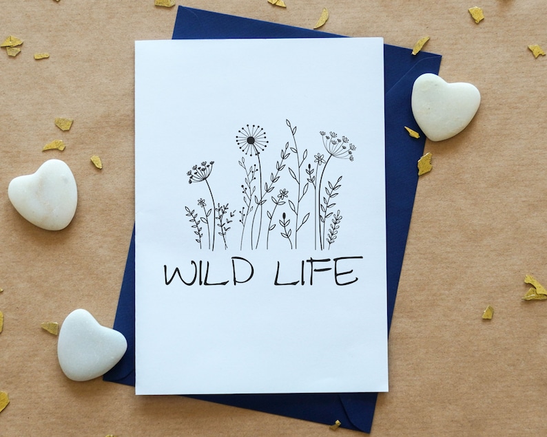 May include: A white card with a black line drawing of wildflowers and the text "WILD LIFE" printed in black.