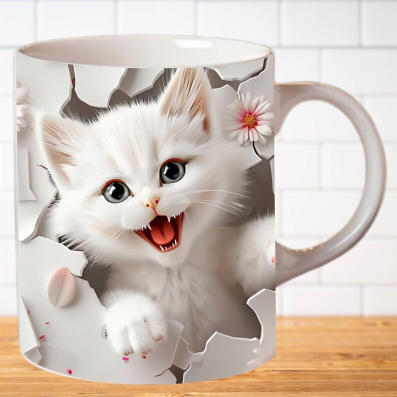 Pu&ograve; includere: Tazza in ceramica bianca con un'immagine 3D di un gattino bianco che spunta da un buco nella tazza. Il gattino ha occhi azzurri brillanti e sorride a bocca aperta.