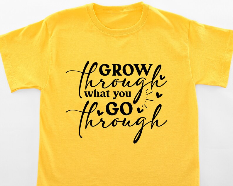 May include: Yellow t-shirt with black text that reads "GROW through what you GO through" with small hearts around the text.