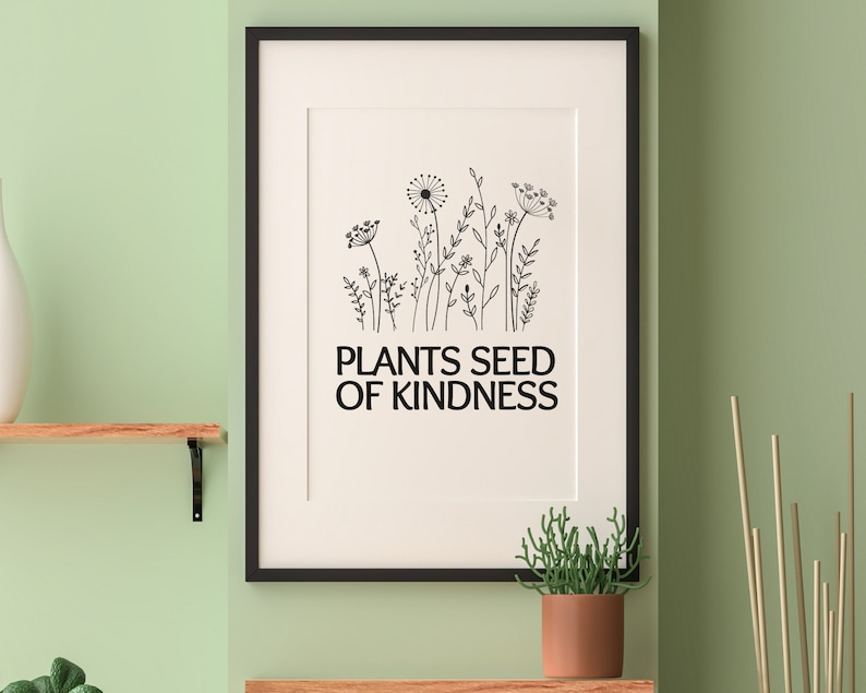 May include: Black and white framed print with a drawing of wildflowers and the text "Plants Seed of Kindness".