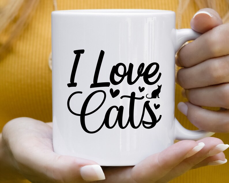 Może przedstawiać: Biały kubek ceramiczny z czarnym nadrukiem "I Love Cats" z sylwetką kota i sercami.