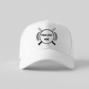 May include: White baseball cap with a black logo featuring crossed baseball bats, a circle with the text "YOUR LOGO HERE" and a laurel wreath.