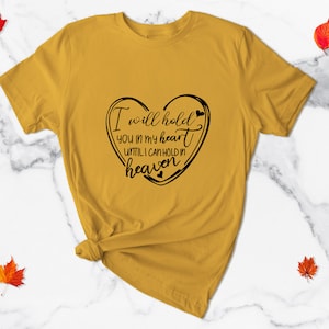May include: A mustard yellow t-shirt with a black heart graphic and the text "I will hold you in my heart until I can hold in heaven".